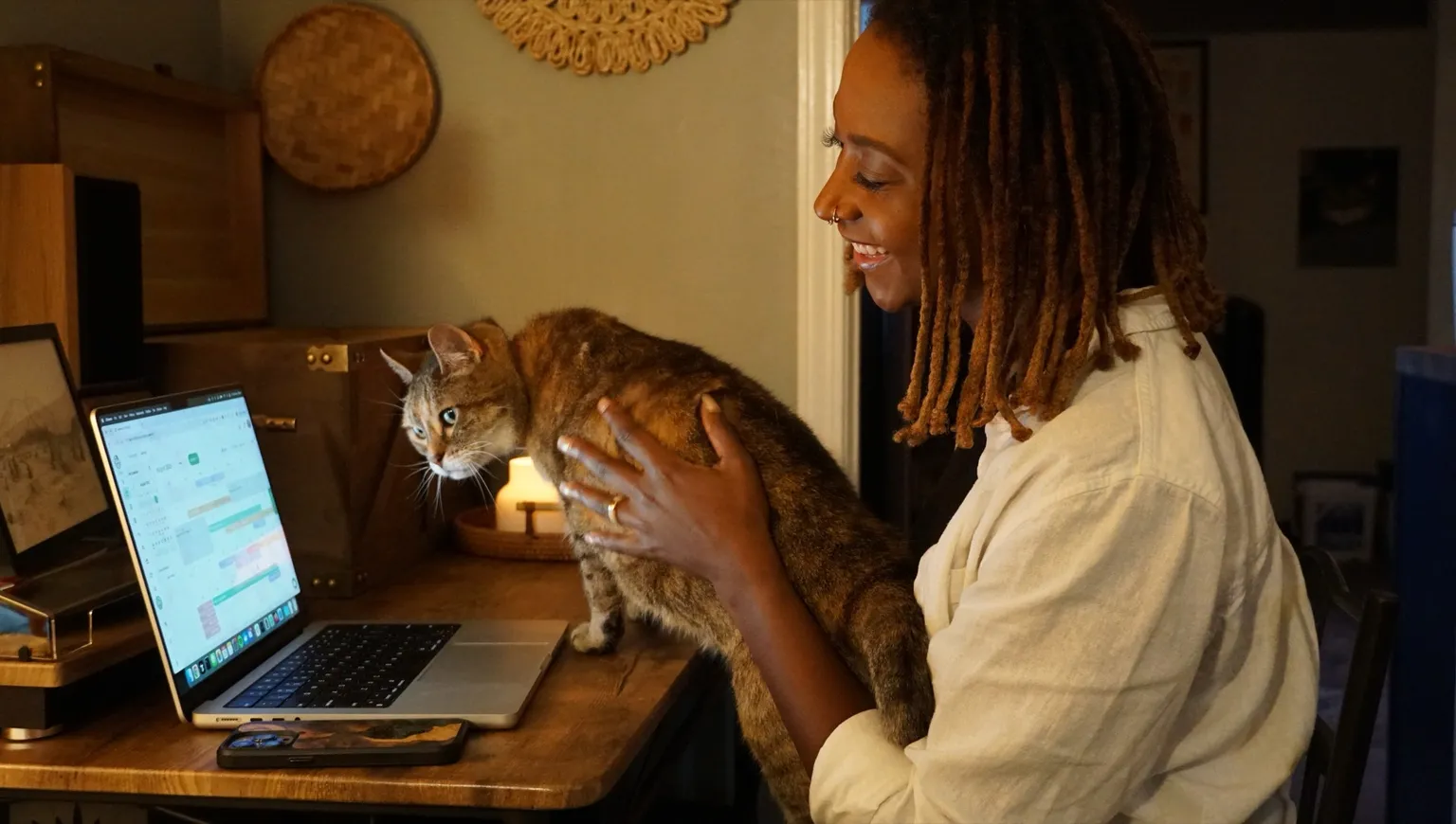 Lucas's wife showing their cat Zen an early version of Scritches on a laptop, 2024